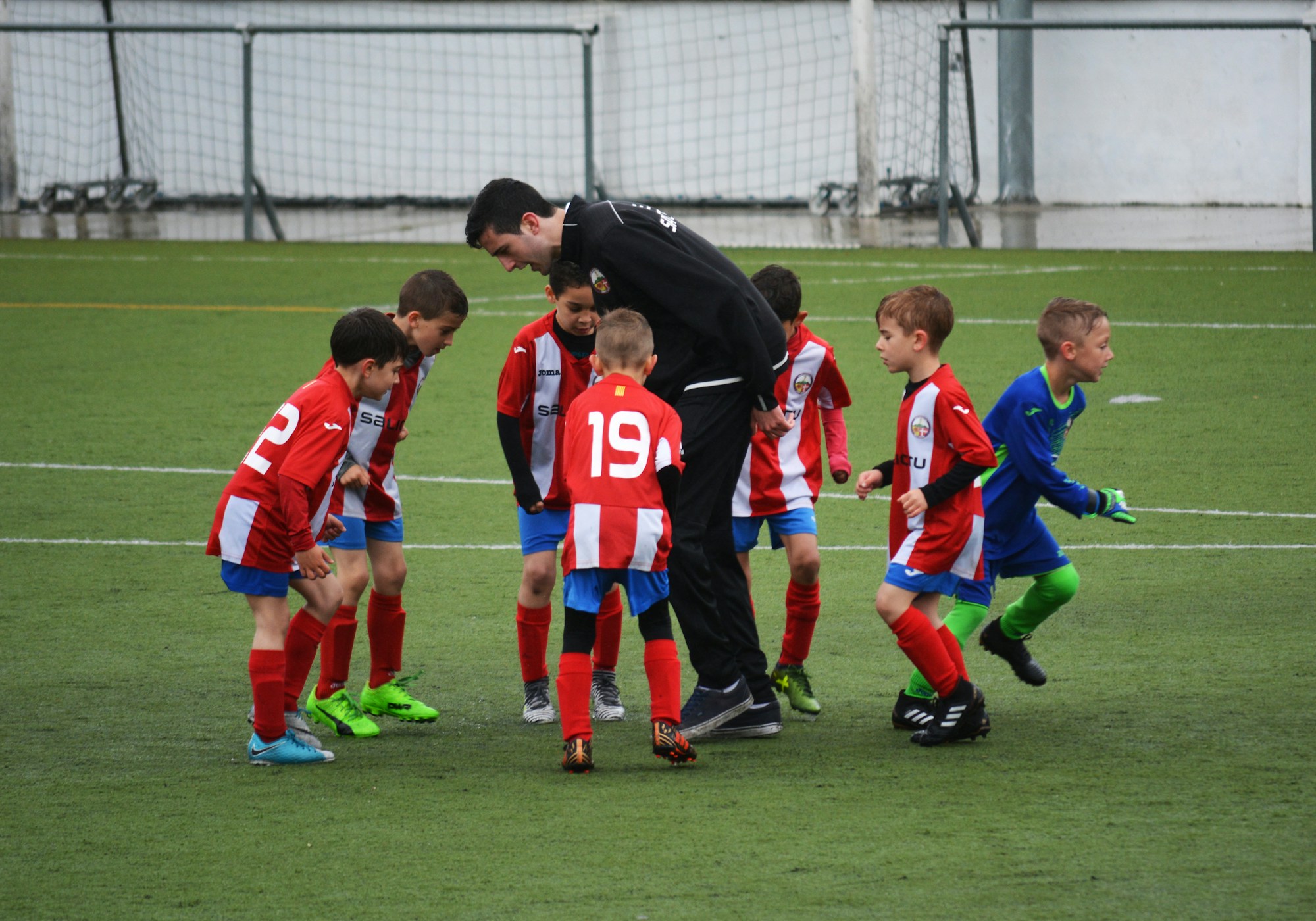 Coach huddling with a youth soccer team - the kind of program CIHW educates
